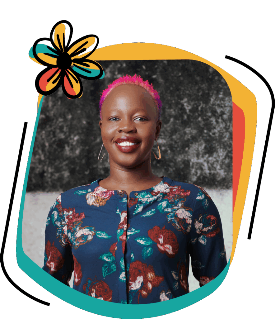 Sophie Otiende is a confident-looking, dark-skinned woman with short hair dyed pink. She is smiling while wearing dark lipstick and gold earrings..